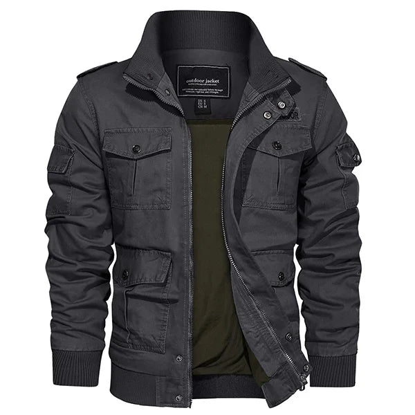 Présentation d'une veste homme baroudeur en teinte grise, combinant style et fonctionnalité pour l'aventurier moderne. Ce vêtement est équipé de nombreuses poches et d'une fermeture éclair pratique, encadrée par des boutons-pression pour une sécurité supplémentaire. Le col montant et les épaulettes renforcent son look robuste, idéal pour ceux qui recherchent un mélange de confort et de résilience dans leur garde-robe urbaine.