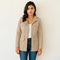 Veste saharienne femme beige portée par un mannequin, coupe cintrée, avec poches à rabat et fermeture à boutons pression, idéale pour un look casual chic.