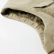Image en gros plan d'une partie d'une veste saharienne sans manche beige montrant l'intérieur doublé de fourrure synthétique grise pour une isolation thermique. La texture détaillée et la finition soignée de la doublure soulignent la qualité et le confort du vêtement, idéal pour la protection contre le froid.