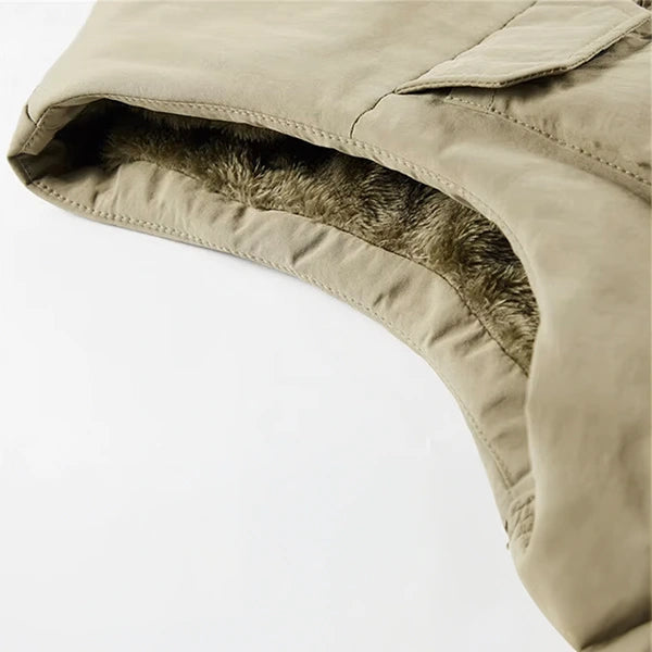 Image en gros plan d'une partie d'une veste saharienne sans manche beige montrant l'intérieur doublé de fourrure synthétique grise pour une isolation thermique. La texture détaillée et la finition soignée de la doublure soulignent la qualité et le confort du vêtement, idéal pour la protection contre le froid.